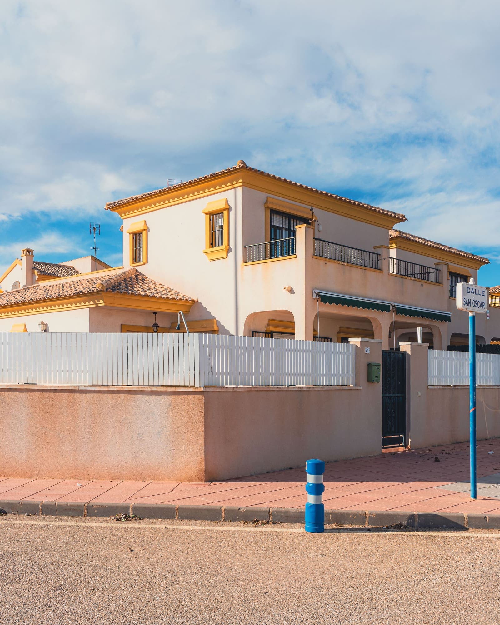 Casa unifamiliar de dos plantas con tejado de teja y valla, en una esquina